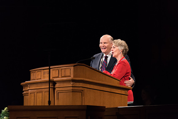 Elder Renlund and Sister Renlund stand together and speak at BYUI devotional. Photo by Garrett Blanchard