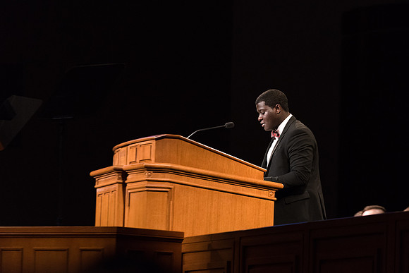 A student reads a scripture at the start of Devotional. 2017