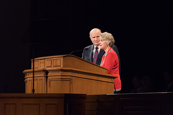 Elder Renlund and Sister Renlund stand together and speak at BYUI devotional. Photo by Garrett Blanchard
