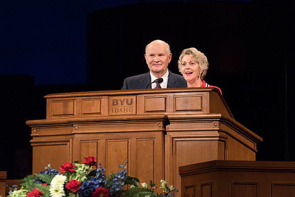 Elder Renlund and Sister Renlund stand together and speak at BYUI devotional. Photo by Garrett Blanchard