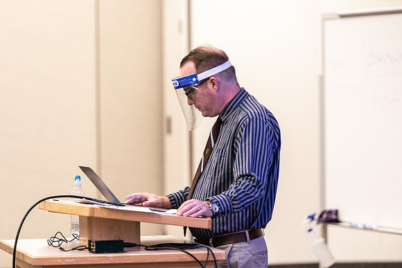 Professor Stratford teaching his humanities class wearing his face shield during Covid-19.