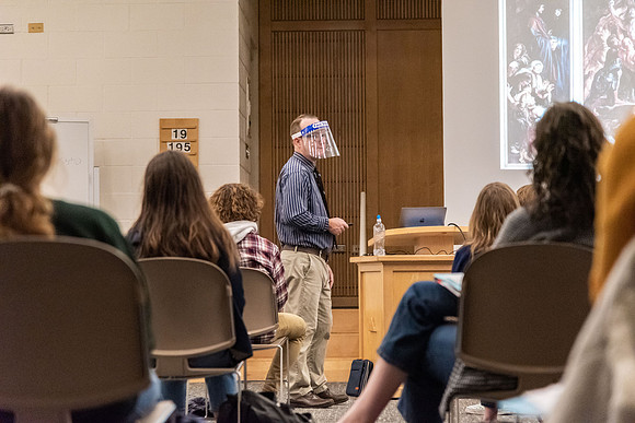 Professor Stratford teaching his humanities class wearing his face shield during Covid-19.