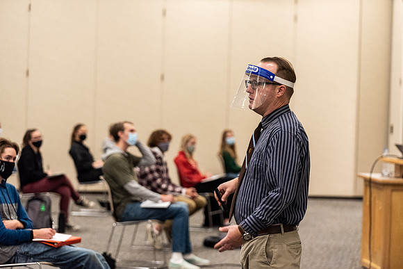Professor Stratford teaching his humanities class wearing his face shield during Covid-19.
