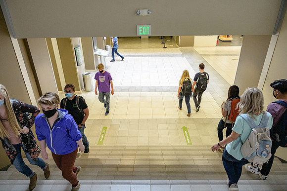 Student volunteers show the way to stay safe during this COVID 19 pandemic by social distancing, following pathway arrows and proper wearing of masks .