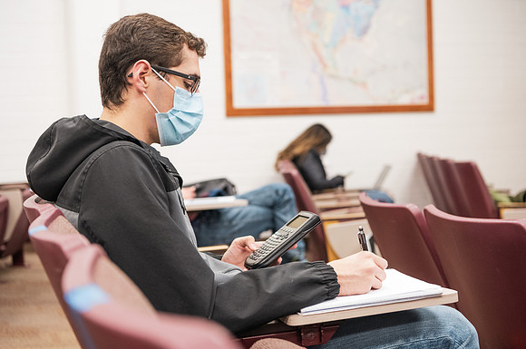 Students in a physics 121 class in the Romney building using social distancing and masks.