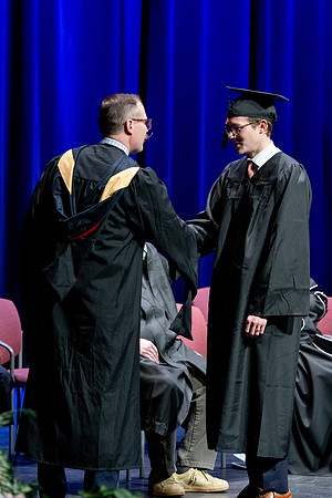 Graduates of the Performing and Visual Arts walk across the stage and accept their diplomas.