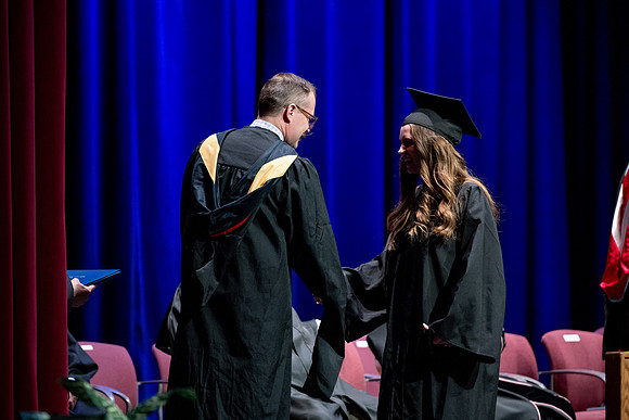 Graduates of the Performing and Visual Arts walk across the stage and accept their diplomas.