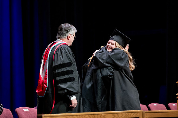 Graduates of the Performing and Visual Arts walk across the stage and accept their diplomas.