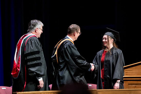 Graduates of the Performing and Visual Arts walk across the stage and accept their diplomas.