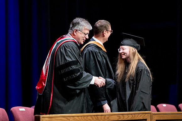Graduates of the Performing and Visual Arts walk across the stage and accept their diplomas.
