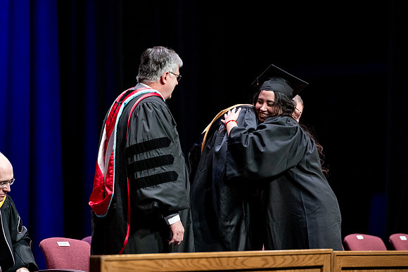 Graduates of the Performing and Visual Arts walk across the stage and accept their diplomas.