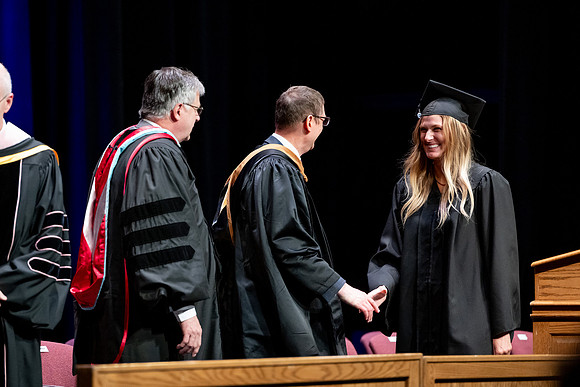 Graduates of the Performing and Visual Arts walk across the stage and accept their diplomas.