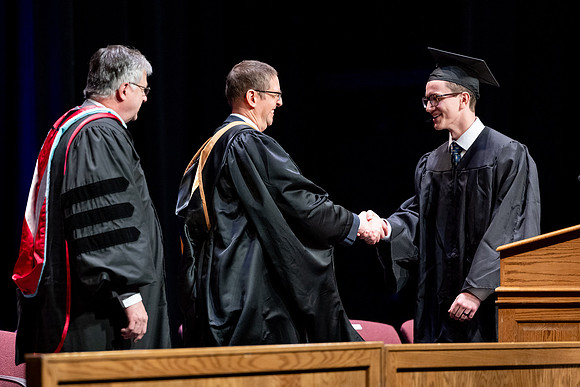 Graduates of the Performing and Visual Arts walk across the stage and accept their diplomas.