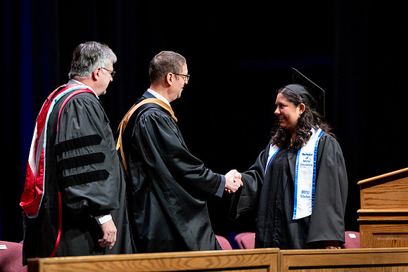 Graduates of the Performing and Visual Arts walk across the stage and accept their diplomas.