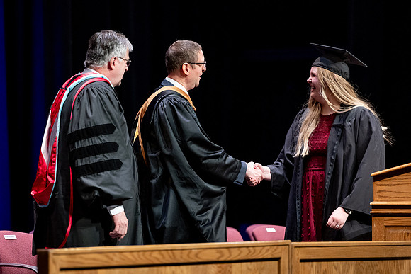 Graduates of the Performing and Visual Arts walk across the stage and accept their diplomas.