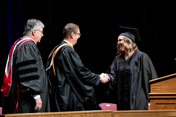 Graduates of the Performing and Visual Arts walk across the stage and accept their diplomas.
