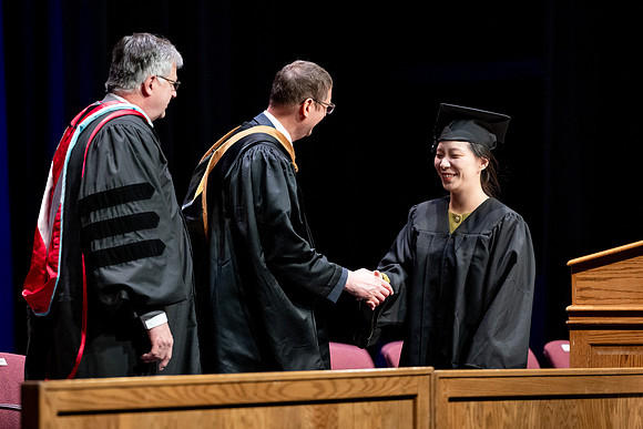 Graduates of the Performing and Visual Arts walk across the stage and accept their diplomas.