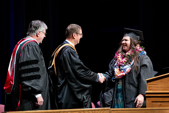 Graduates of the Performing and Visual Arts walk across the stage and accept their diplomas.