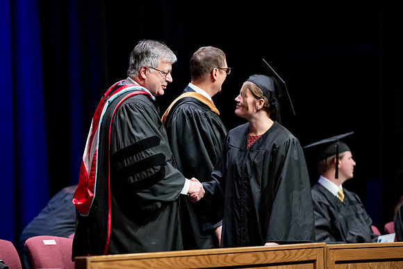 Graduates of the Performing and Visual Arts walk across the stage and accept their diplomas.