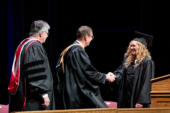 Graduates of the Performing and Visual Arts walk across the stage and accept their diplomas.