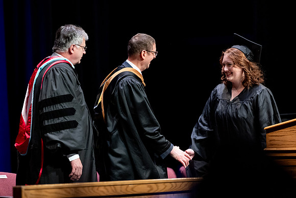 Graduates of the Performing and Visual Arts walk across the stage and accept their diplomas.
