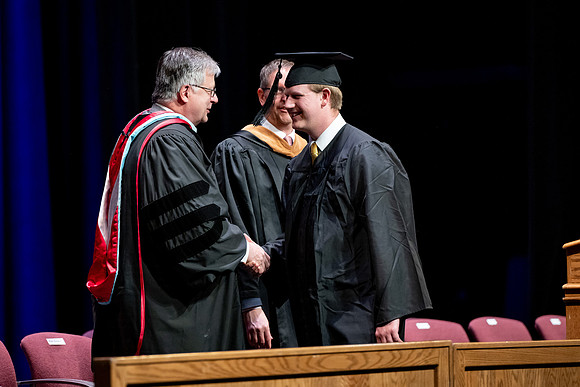 Graduates of the Performing and Visual Arts walk across the stage and accept their diplomas.