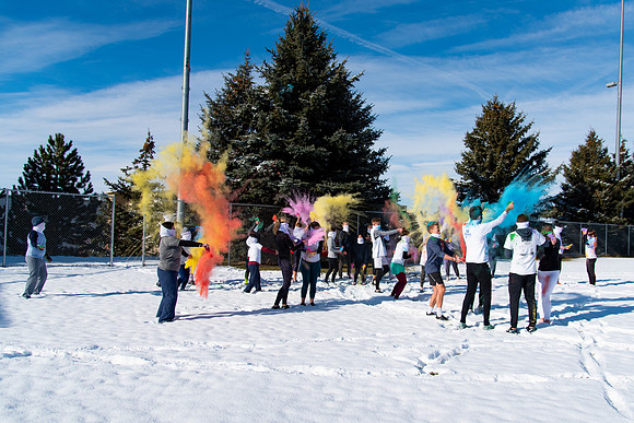 Students and their families throwing colored chalk before the race starts.