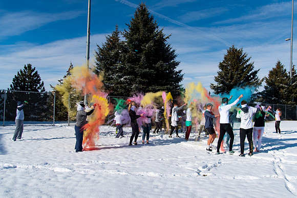 Students and their families throwing colored chalk before the race starts.