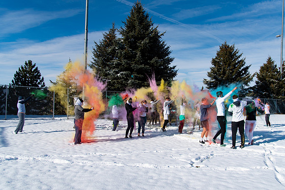 Students and their families throwing colored chalk before the race starts.