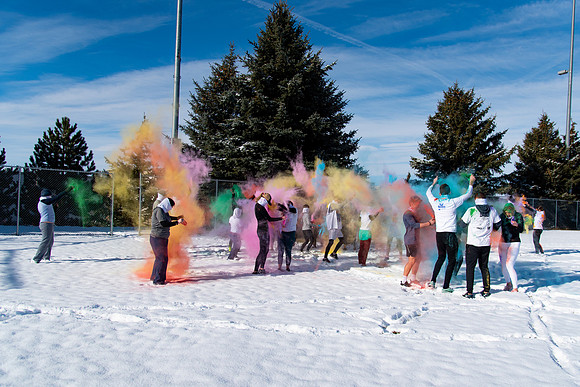 Students and their families throwing colored chalk before the race starts.