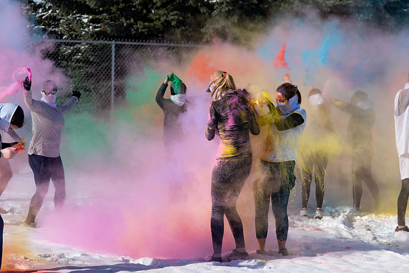 Students and their families throwing colored chalk before the race starts.