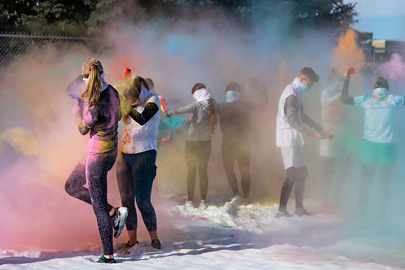Students and their families throwing colored chalk before the race starts.