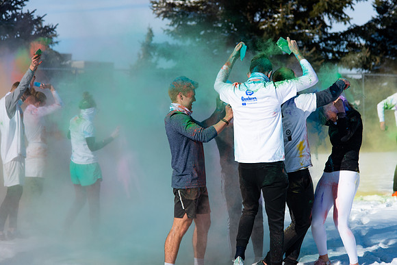 Students and their families throwing colored chalk before the race starts.