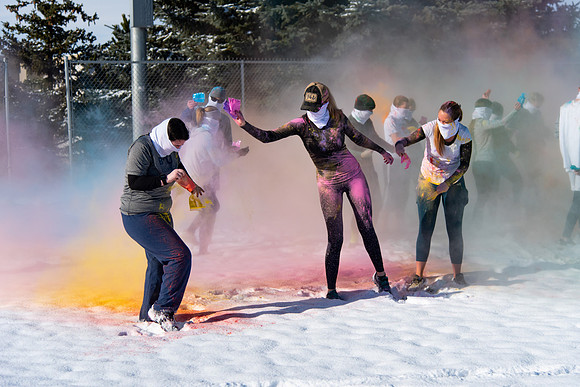 Students and their families throwing colored chalk before the race starts.