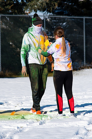 Students and their families throwing colored chalk before the race starts.