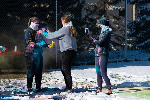 Students and their families throwing colored chalk before the race starts.