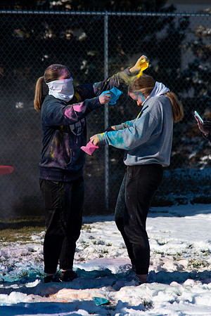 Students and their families throwing colored chalk before the race starts.