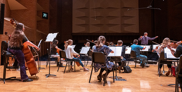 String instruments practice in the Barrus Concert Hall under the direction of Robert Tueller.