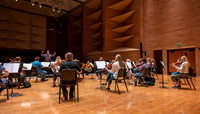 String instruments practice in the Barrus Concert Hall under the direction of Robert Tueller.