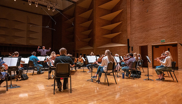 String instruments practice in the Barrus Concert Hall under the direction of Robert Tueller.