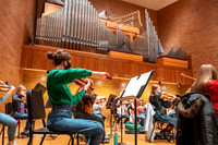 String instruments practice in the Barrus Concert Hall under the direction of Robert Tueller.