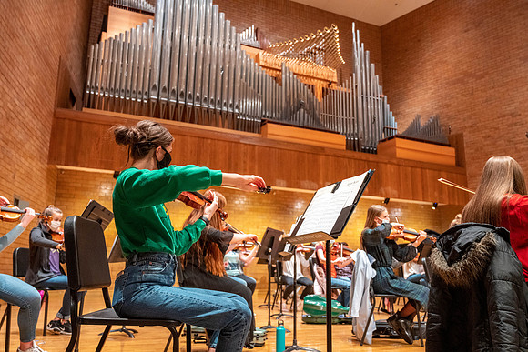 String instruments practice in the Barrus Concert Hall under the direction of Robert Tueller.