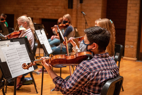 String instruments practice in the Barrus Concert Hall under the direction of Robert Tueller.