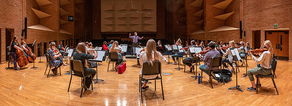 String instruments practice in the Barrus Concert Hall under the direction of Robert Tueller.