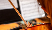 String instruments practice in the Barrus Concert Hall under the direction of Robert Tueller.