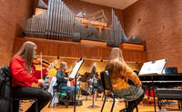 String instruments practice in the Barrus Concert Hall under the direction of Robert Tueller.