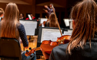 String instruments practice in the Barrus Concert Hall under the direction of Robert Tueller.