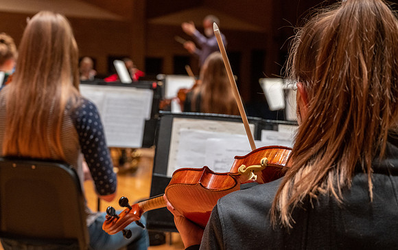 String instruments practice in the Barrus Concert Hall under the direction of Robert Tueller.