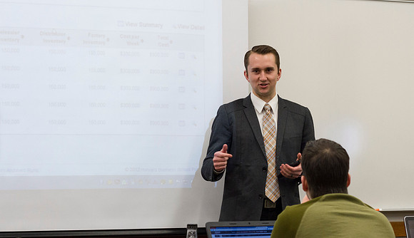 Ryan, a student in the Business Productions and Operations Management class, shares a current event with fellow students.