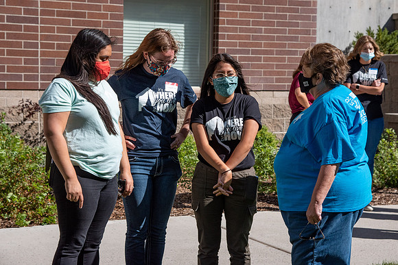 Students with the housing and student living council wearing face masks while out talking to one another.